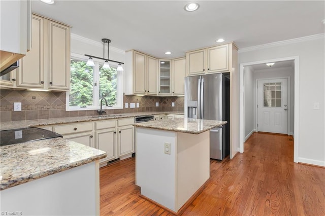 kitchen with ornamental molding, cream cabinetry, a sink, and stainless steel fridge with ice dispenser