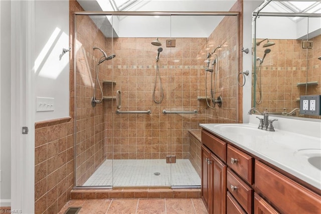 full bathroom featuring a stall shower, double vanity, and a sink