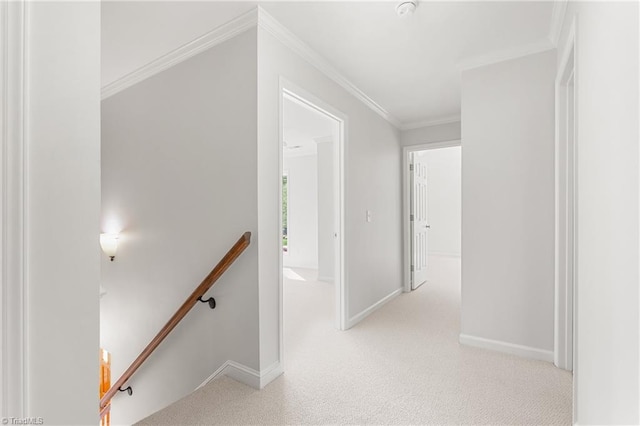 hall with baseboards, light colored carpet, an upstairs landing, and crown molding