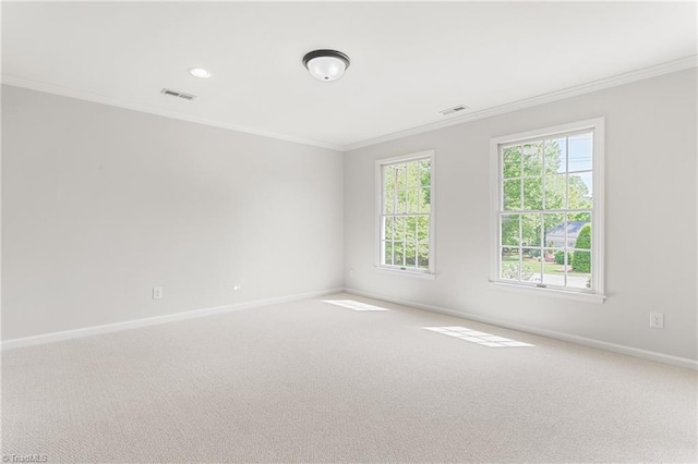 carpeted empty room featuring visible vents, ornamental molding, and baseboards
