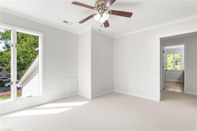 unfurnished room featuring crown molding, visible vents, light carpet, and baseboards