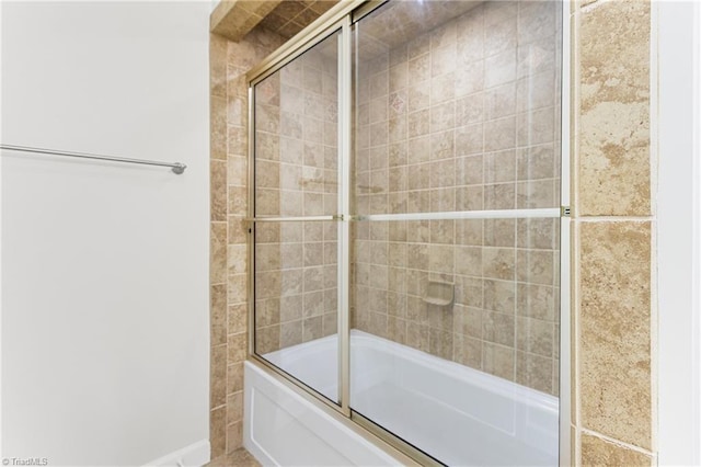 bathroom with bath / shower combo with glass door