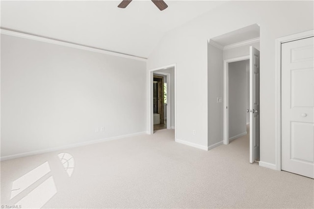 unfurnished bedroom featuring vaulted ceiling, light carpet, baseboards, a ceiling fan, and crown molding