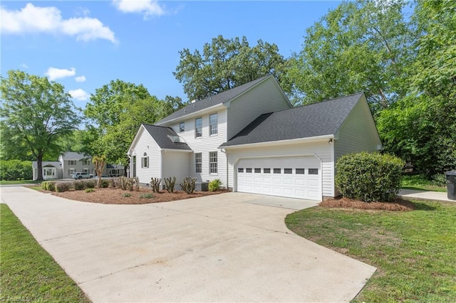 colonial-style house featuring a front yard, concrete driveway, and a garage