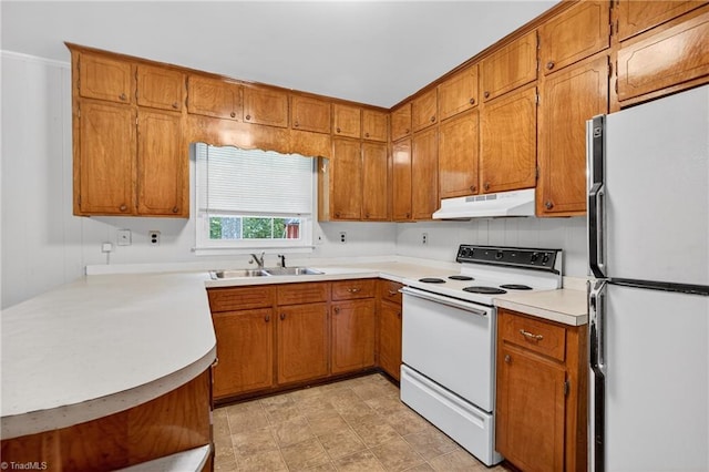 6006 Dehaven Rd, Pleasant Garden, NC 27313 - kitchen featuring white appliances, under cabinet range hood, brown cabinetry, and light countertops