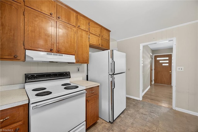 6006 Dehaven Rd, Pleasant Garden, NC 27313 - kitchen with white appliances, under cabinet range hood, brown cabinetry, light countertops, and ornamental molding