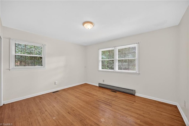 6006 Dehaven Rd, Pleasant Garden, NC 27313 - empty room featuring a baseboard radiator, plenty of natural light, and wood finished floors