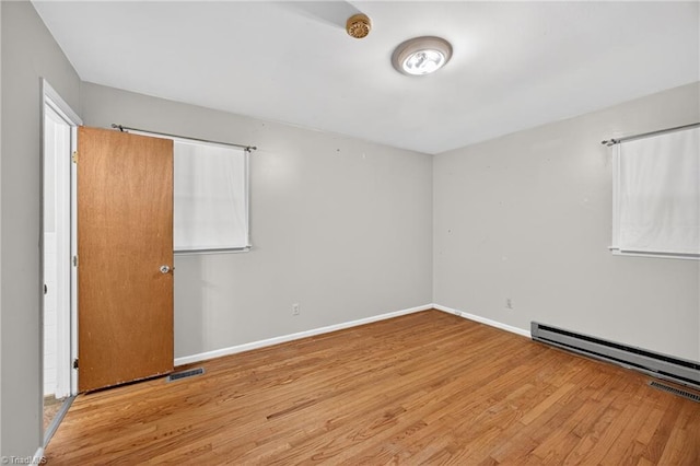 6006 Dehaven Rd, Pleasant Garden, NC 27313 - unfurnished bedroom with wood finished floors and a baseboard radiator