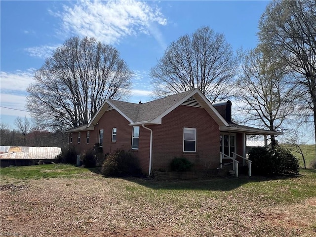 view of property exterior with brick siding and a yard
