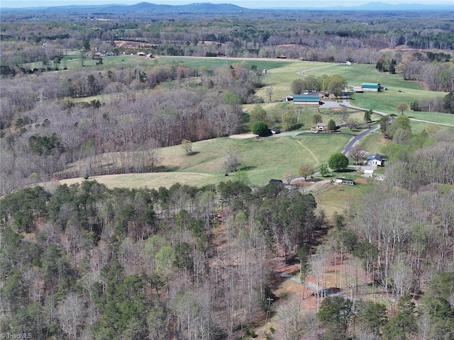 birds eye view of property with a wooded view, a mountain view, and a rural view