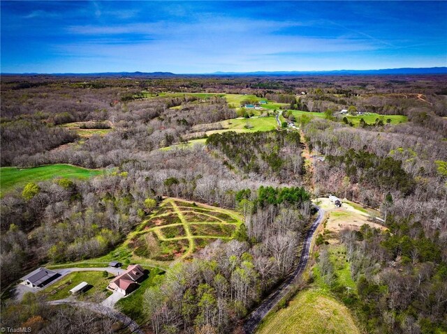 drone / aerial view featuring a wooded view