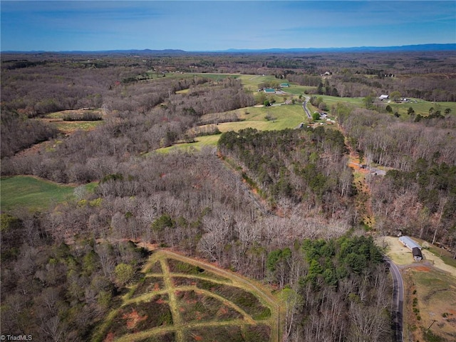 birds eye view of property featuring a forest view