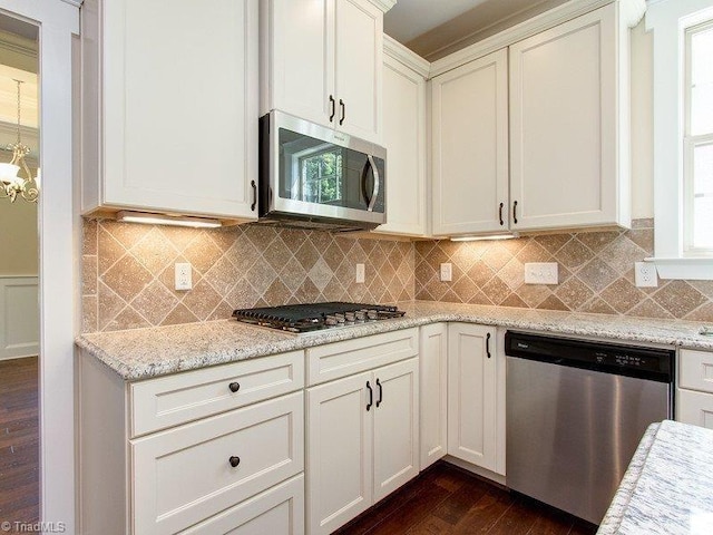 kitchen with stainless steel appliances, light stone counters, dark hardwood / wood-style flooring, and tasteful backsplash