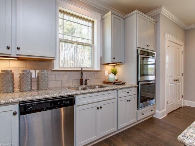 kitchen with stainless steel appliances, sink, dark wood-type flooring, and light stone counters