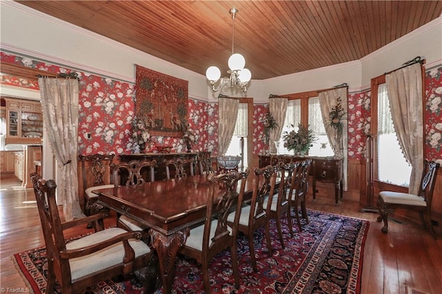 dining space with ornamental molding, wood-type flooring, an inviting chandelier, and wooden ceiling