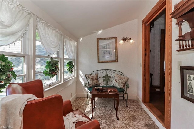 living area with a wealth of natural light, vaulted ceiling, and carpet flooring