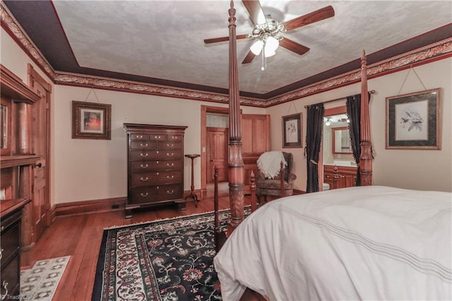 bedroom featuring ensuite bath, dark hardwood / wood-style floors, and ceiling fan