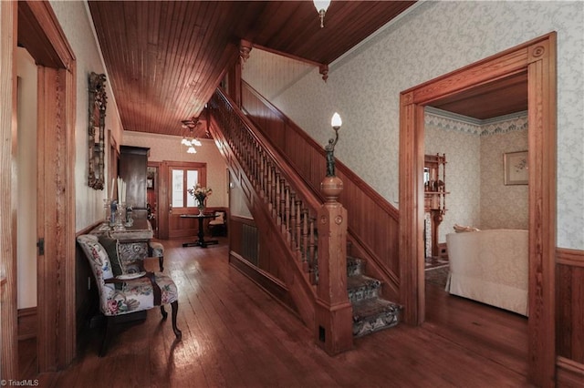 stairs featuring wood ceiling, dark wood-type flooring, and ornamental molding