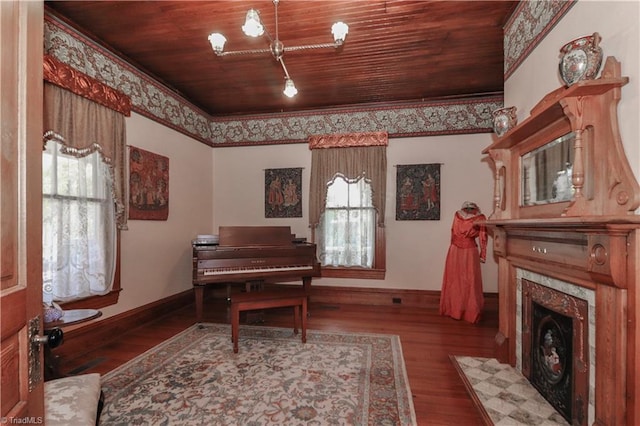 sitting room with ornamental molding, dark hardwood / wood-style floors, and wooden ceiling