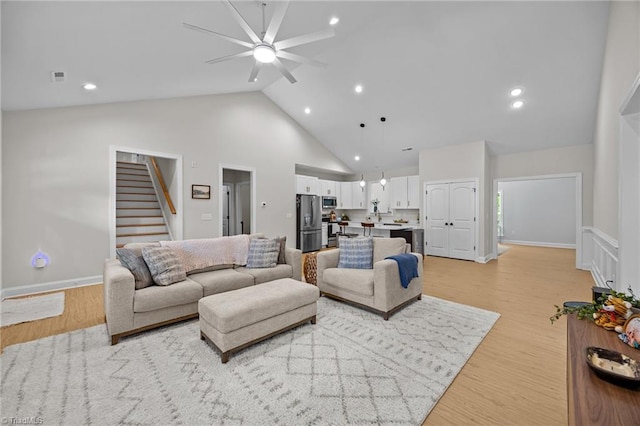 4944 Little Store Rd, Mcleansville, NC 27301 - living room featuring stairway, ceiling fan, light wood-style floors, high vaulted ceiling, and recessed lighting