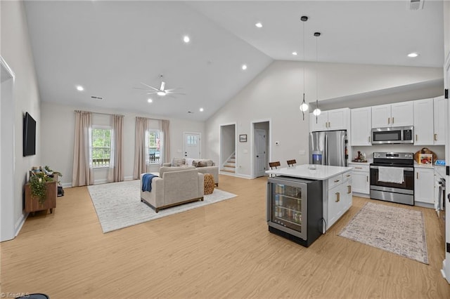 4944 Little Store Rd, Mcleansville, NC 27301 - kitchen with appliances with stainless steel finishes, wine cooler, light wood-style flooring, open floor plan, and white cabinetry