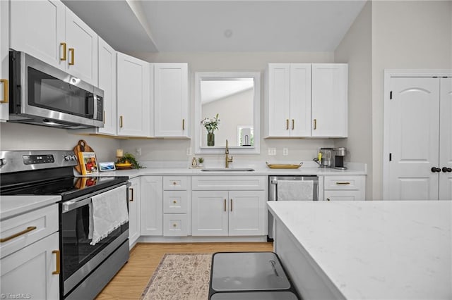 4944 Little Store Rd, Mcleansville, NC 27301 - kitchen featuring stainless steel appliances, a sink, lofted ceiling, white cabinets, and light wood-style flooring