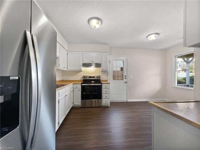 kitchen with appliances with stainless steel finishes, white cabinetry, dark wood finished floors, and under cabinet range hood