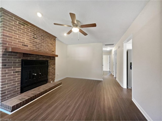 unfurnished living room with a fireplace, wood finished floors, a ceiling fan, and baseboards