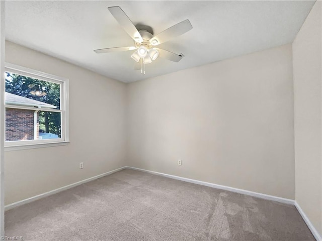 carpeted empty room with a ceiling fan and baseboards