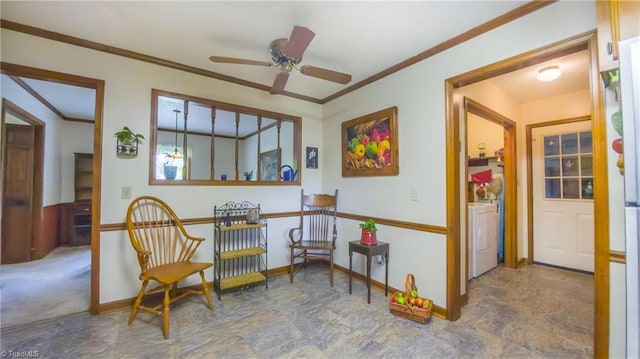 sitting room featuring separate washer and dryer, crown molding, a ceiling fan, and baseboards