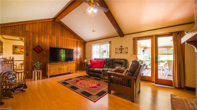 living area featuring a ceiling fan, wood finished floors, and wood walls