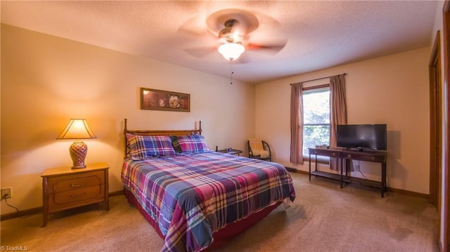 bedroom featuring light carpet, baseboards, a textured ceiling, and a ceiling fan