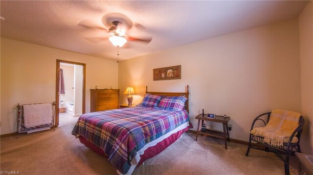 bedroom with carpet floors, baseboards, ensuite bathroom, and a ceiling fan