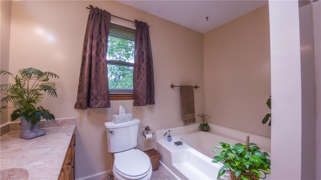 bathroom featuring vanity, a garden tub, toilet, and baseboards
