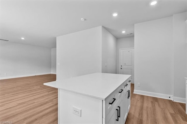 4192 Emmas Way E, Bend, NC 27018 - kitchen with light wood-type flooring, baseboards, a center island, recessed lighting, and light countertops