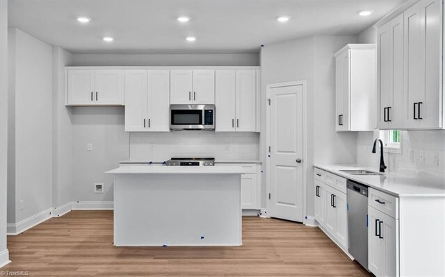 4192 Emmas Way E, Bend, NC 27018 - kitchen featuring appliances with stainless steel finishes, a sink, decorative backsplash, white cabinets, and recessed lighting