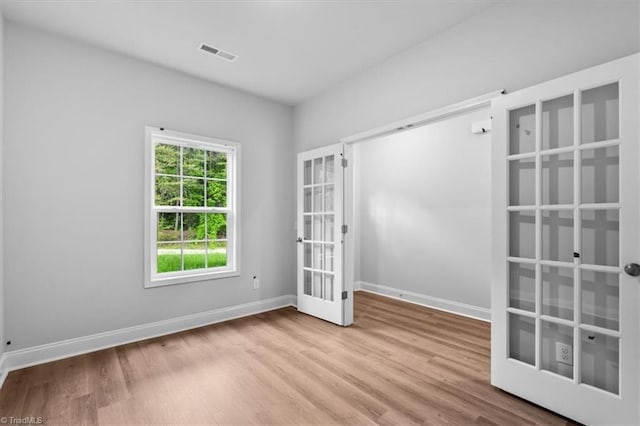 4192 Emmas Way E, Bend, NC 27018 - empty room featuring wood finished floors, baseboards, and french doors