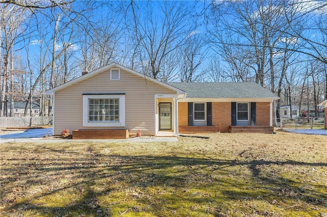 ranch-style house featuring covered porch and a front yard