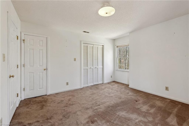 401 Joyce Rd, Hillsborough, NC 27278 - unfurnished bedroom with a closet, a textured ceiling, visible vents, baseboards, and carpet floors