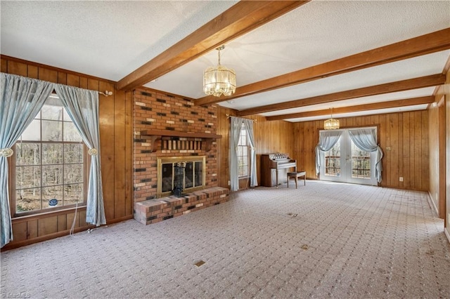 401 Joyce Rd, Hillsborough, NC 27278 - unfurnished living room featuring wood walls, a chandelier, a textured ceiling, carpet floors, and beamed ceiling