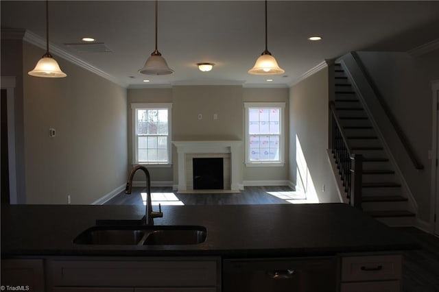 kitchen featuring dark countertops, dishwasher, a wealth of natural light, and a sink