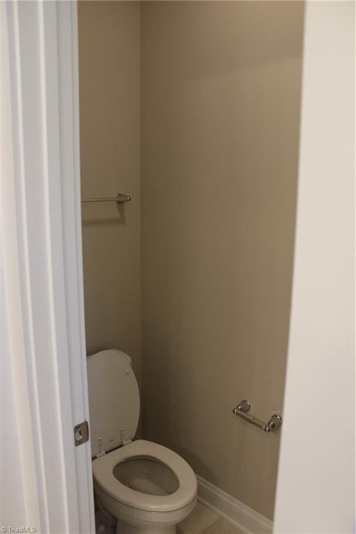 bathroom with toilet and baseboards