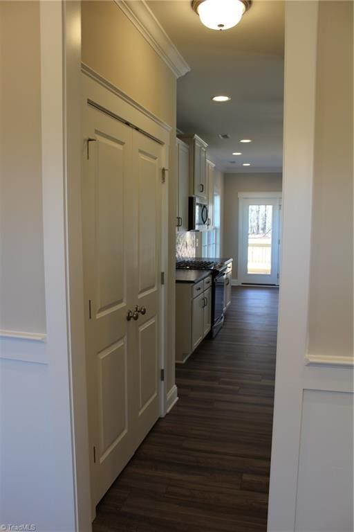 corridor with ornamental molding, dark wood-style flooring, and recessed lighting