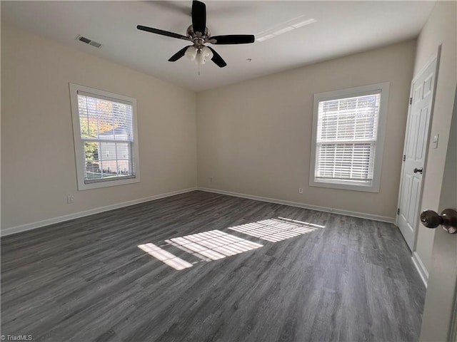 empty room featuring dark hardwood / wood-style flooring, ceiling fan, and plenty of natural light