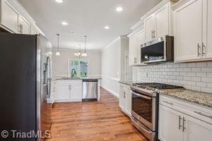 2834 Fallin Ct, High Point, NC 27262 - kitchen featuring appliances with stainless steel finishes, recessed lighting, tasteful backsplash, light wood-type flooring, and crown molding