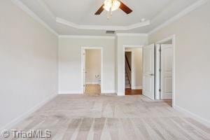 2834 Fallin Ct, High Point, NC 27262 - unfurnished bedroom featuring a raised ceiling, ornamental molding, ensuite bath, and carpet