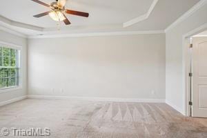 2834 Fallin Ct, High Point, NC 27262 - carpeted empty room featuring a raised ceiling, crown molding, and ceiling fan