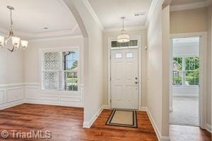 2834 Fallin Ct, High Point, NC 27262 - entryway featuring crown molding, arched walkways, wood finished floors, and a chandelier