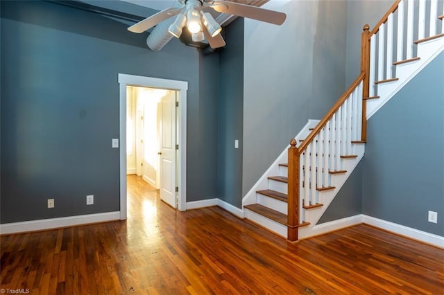 staircase featuring ceiling fan and hardwood / wood-style floors