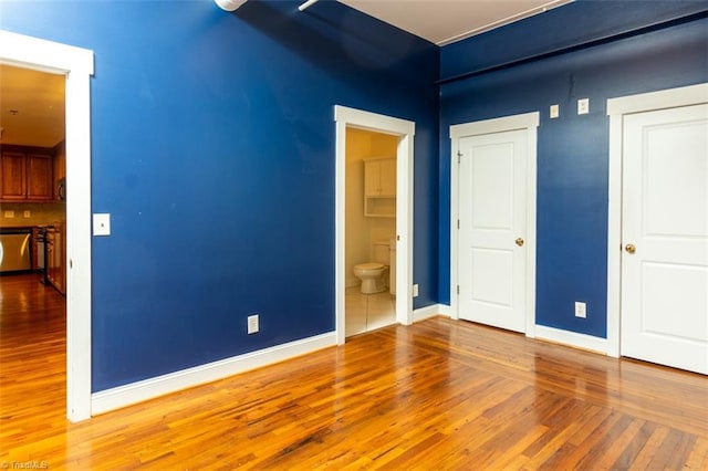 interior space with hardwood / wood-style flooring and connected bathroom